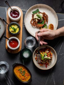 multiple curry bowls arrangement with various Indian dishes