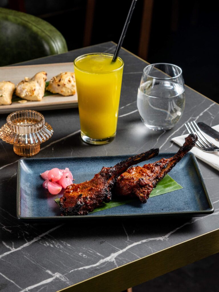 Breakfast items with orange juice and plated meal on wooden table