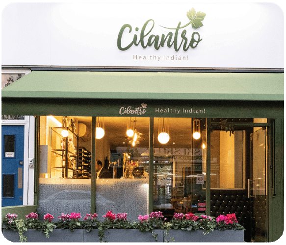 Cilantro restaurant exterior storefront with modern signage and evening lighting